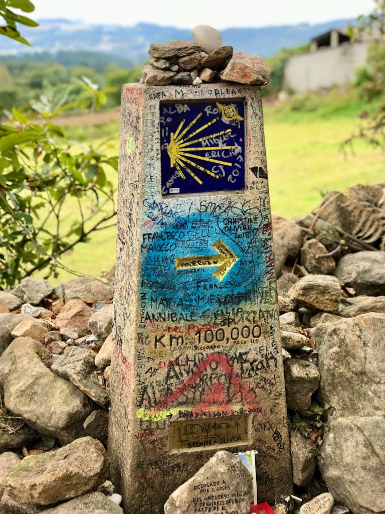 Stone milestone with Camino de Santiago sign in Paradela, Spain.
