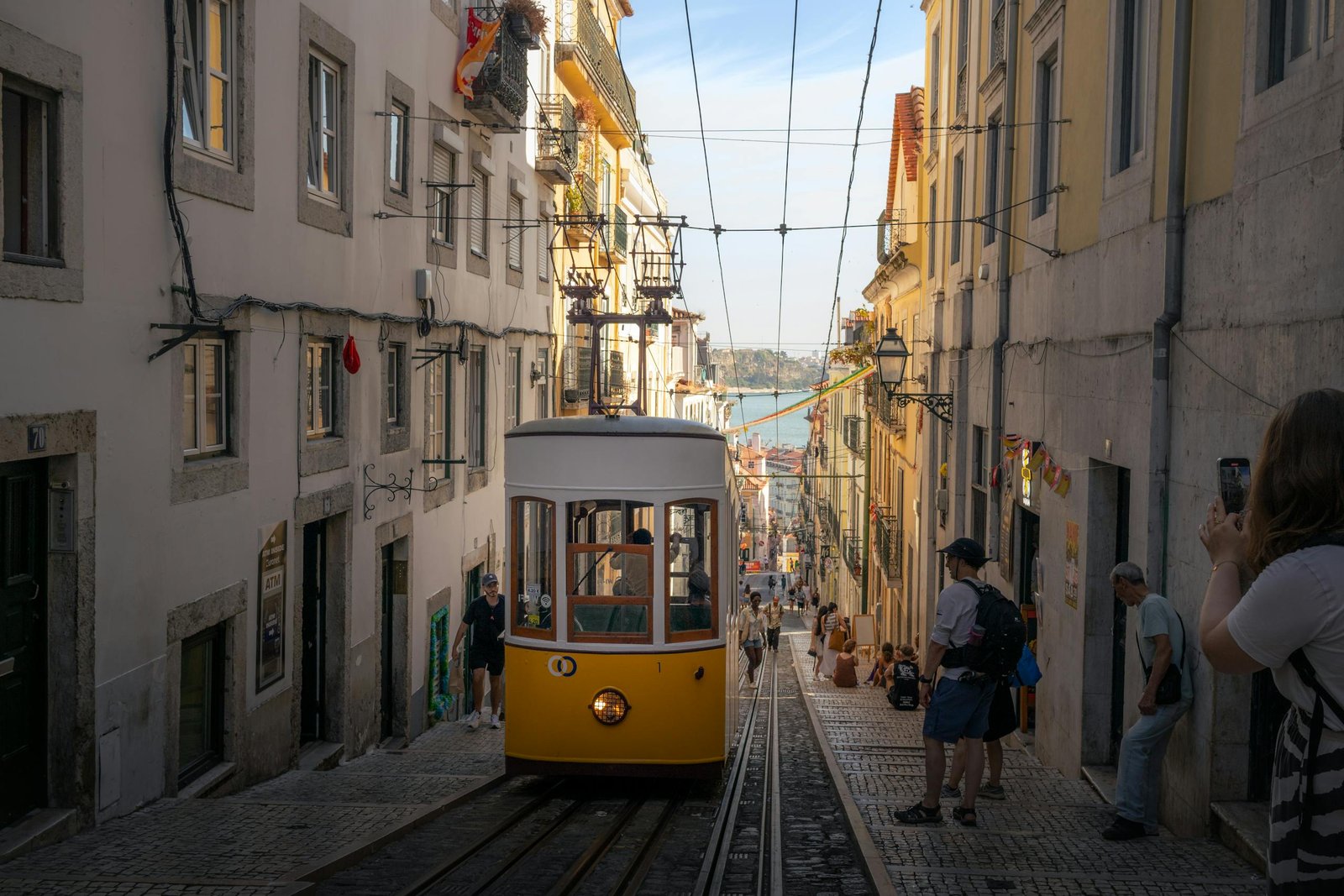 A classic yellow tram navigates a steep street in Lisbon, Portugal, capturing the city's historic charm. Getting Around Lisbon