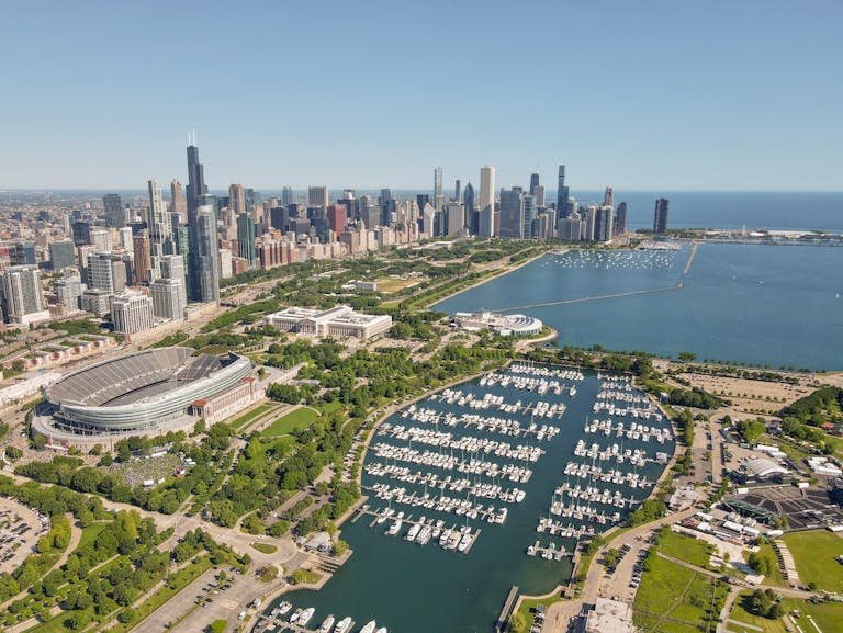 A stunning aerial shot of Chicago's skyline and Lake Michigan with Soldier Field in sight.