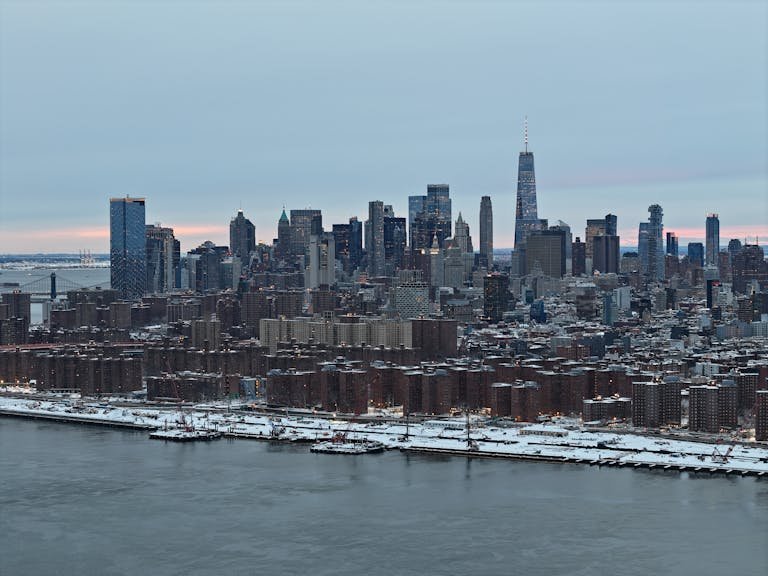 A stunning aerial shot of New York City skyline covered in snow during the day.