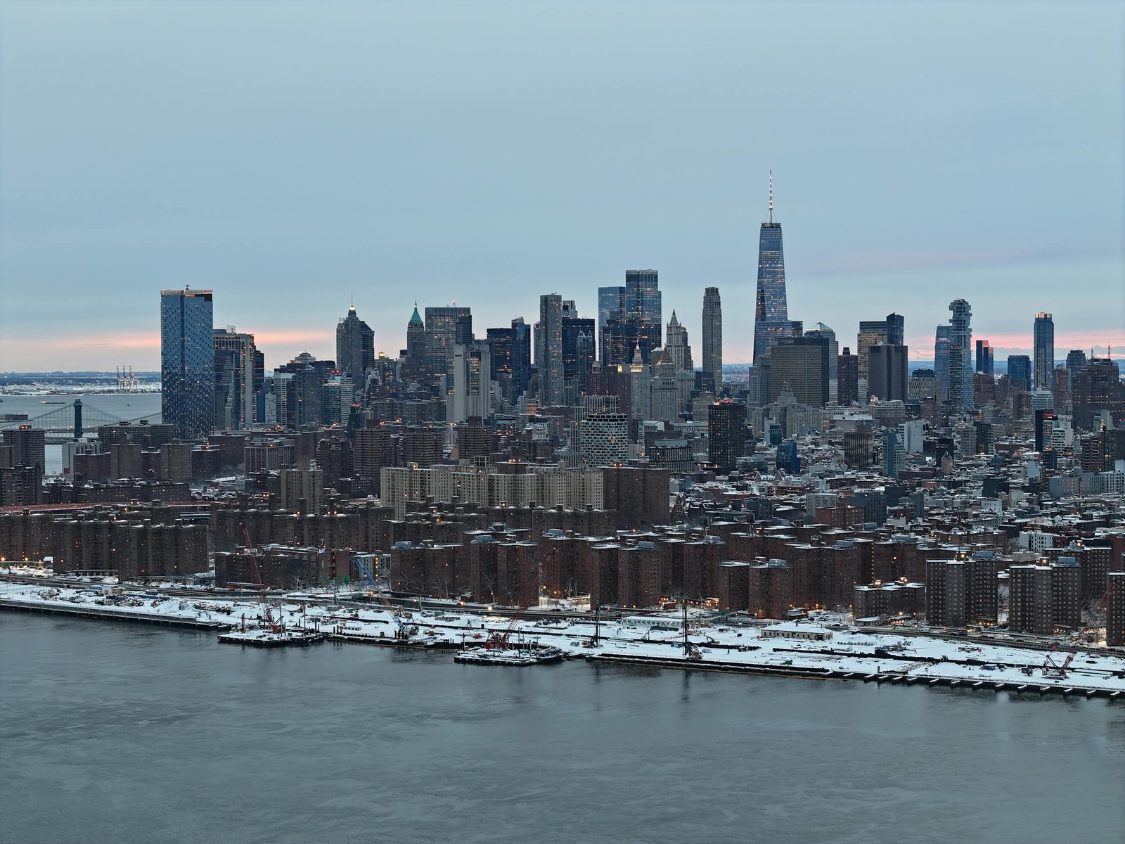 A stunning aerial shot of New York City skyline covered in snow during the day.