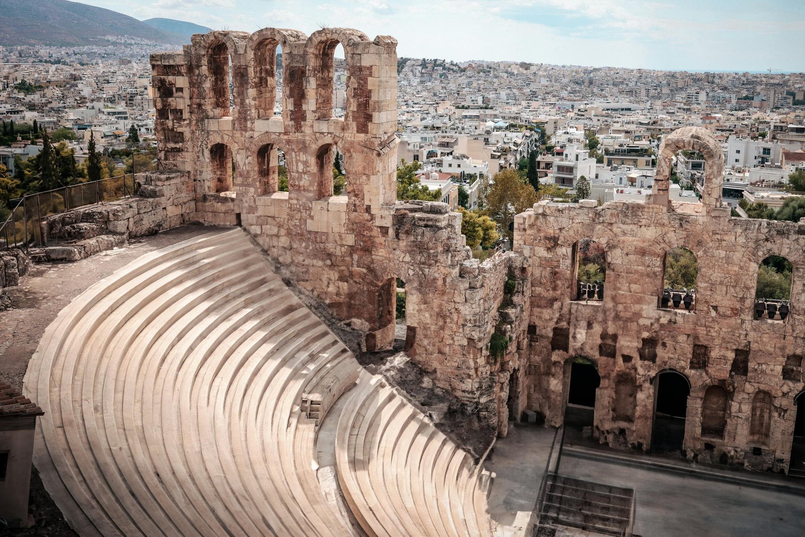Ancient Odeon of Herodes Atticus amphitheater overlooking Athens cityscape.
