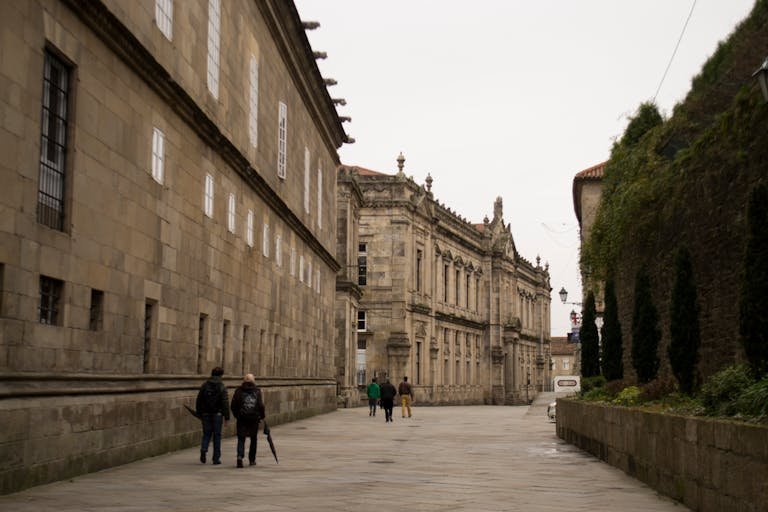People walking along a historical street in Santiago de Compostela, Spain.