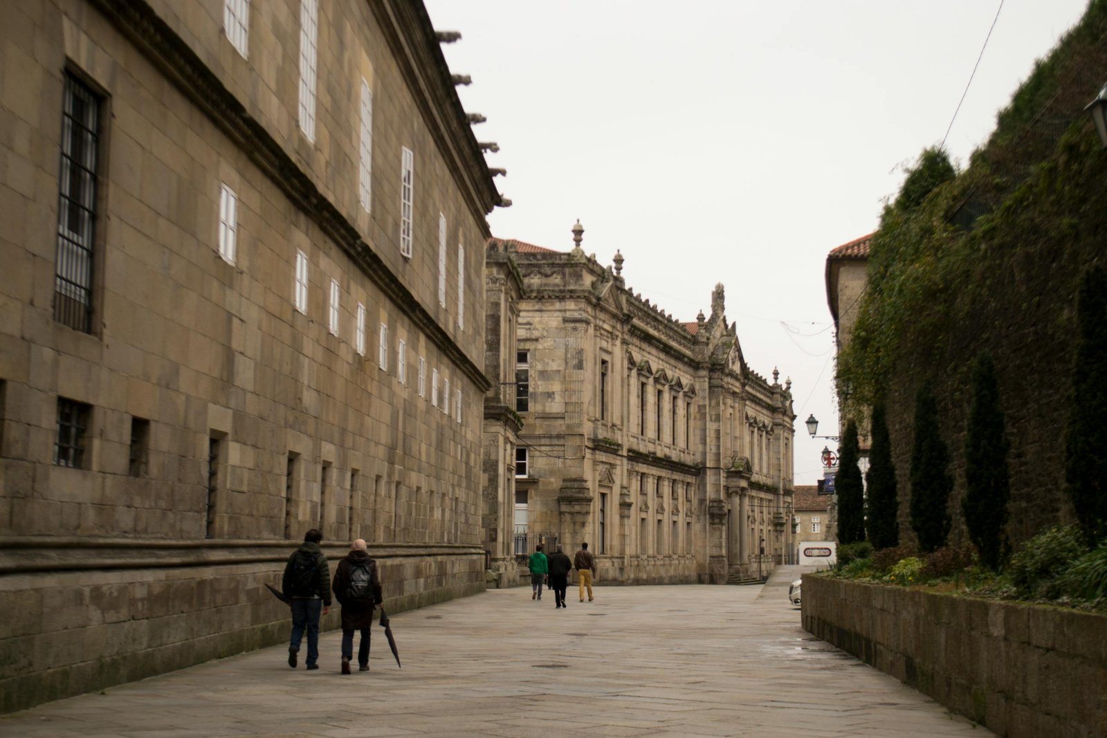 People walking along a historical street in Santiago de Compostela, Spain.
