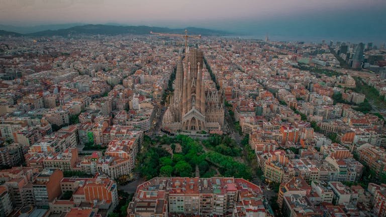 Stunning aerial photo of Sagrada Familia amidst Barcelona cityscape at twilight. - What to do