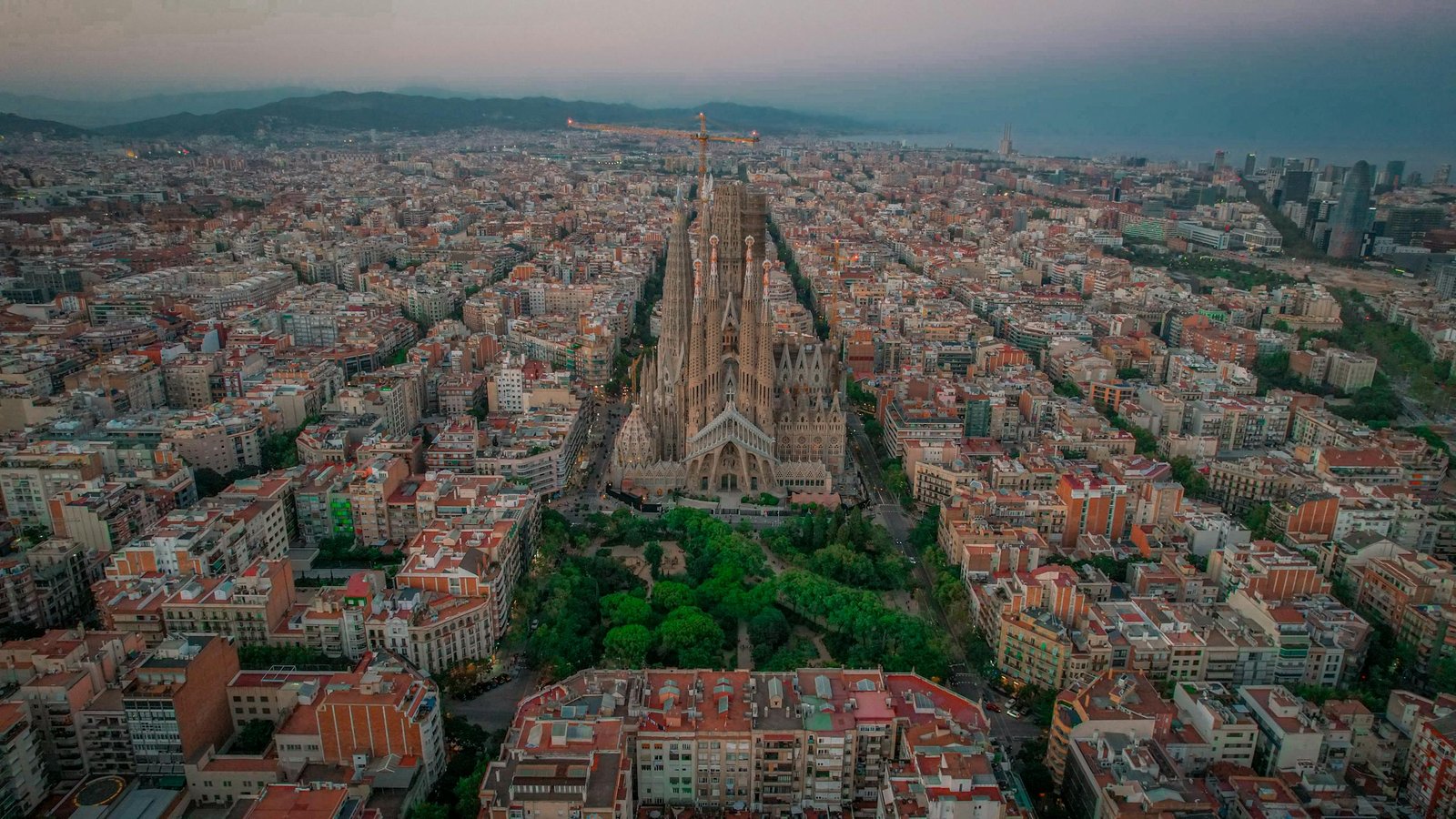 Stunning aerial photo of Sagrada Familia amidst Barcelona cityscape at twilight. - What to do