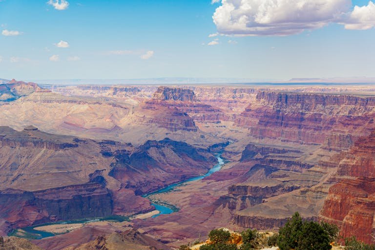 Stunning panorama of the Grand Canyon with the Colorado River under a blue sky.