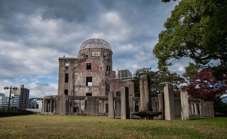The iconic Hiroshima Peace Memorial Dome against a cloudy sky in Hiroshima, Japan.