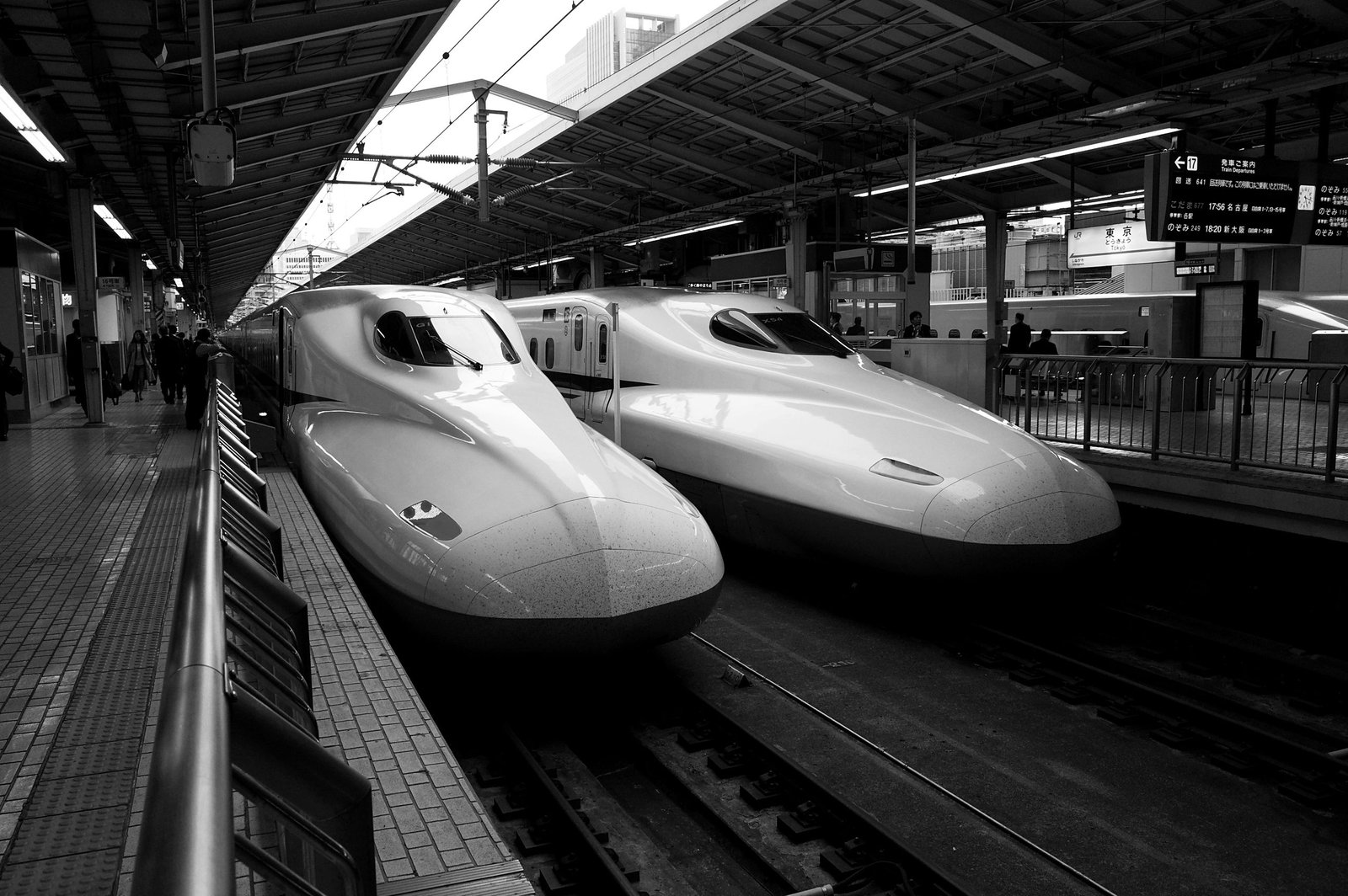 Japan Rail Pass Guide: First Timer's Tips 1 Black and white photo of Shinkansen trains at a busy Tokyo station platform.