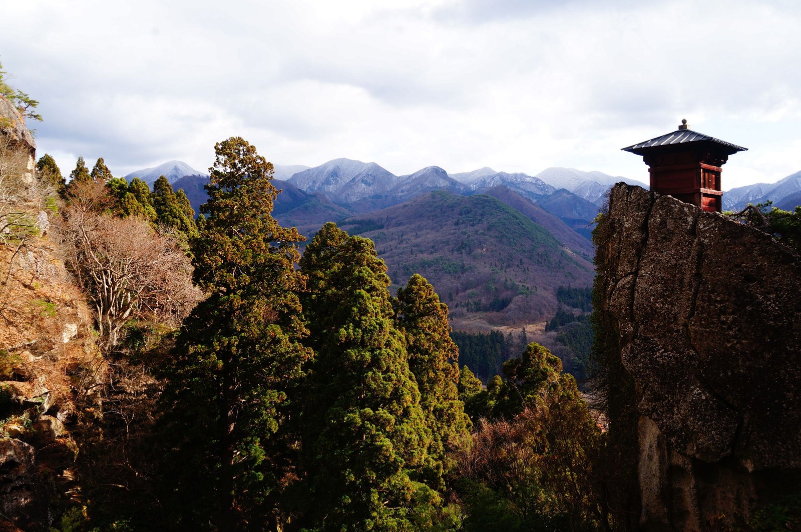 Explore the tranquil beauty of Japan's mountain landscape with a temple and lush greenery.
